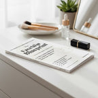 Book titled 'The Face Slim Blueprint' on a white surface with makeup items.